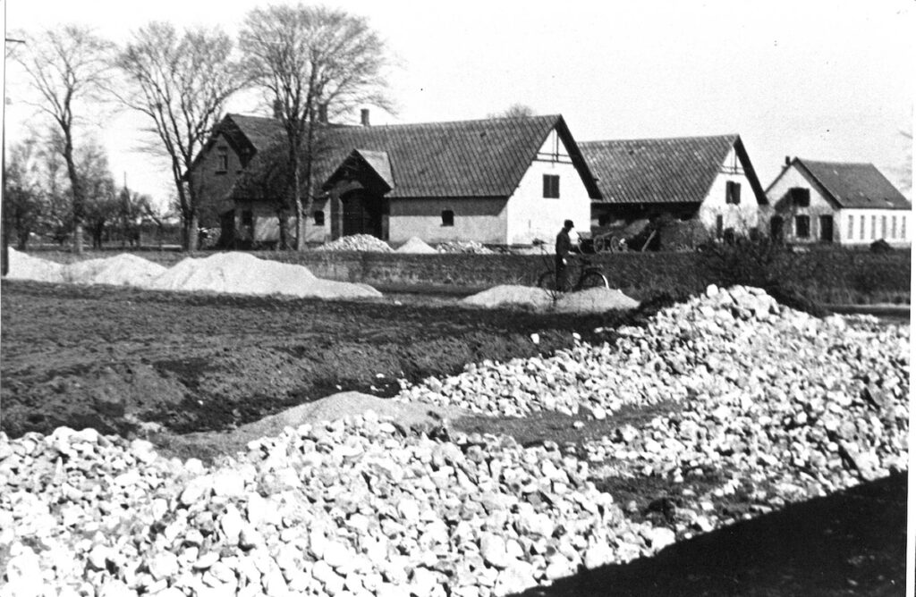 I 1944 anlagde Luftwaffe en 8 km lang, 12 m bred betonrullebane over markerne i Store Magleby. I baggrunden ses Den nye Lundegård (opført 1905) med de nu nedrevne længer. Foto: DB Arkiv