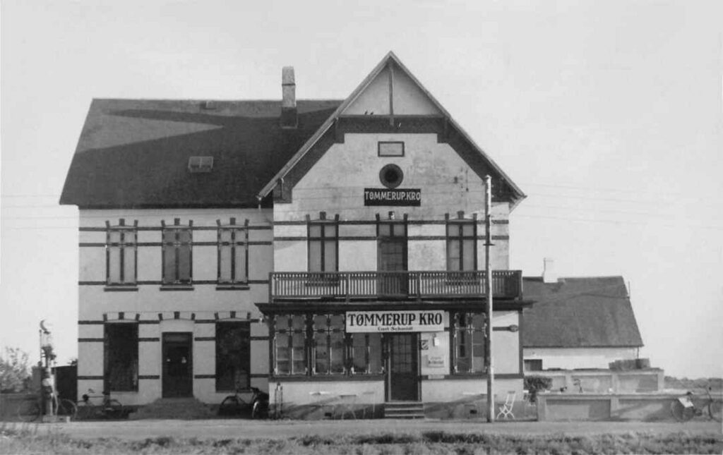 Ca. 1942. Det er restauratør Carl Schmidt, der driver kroen under Besættelsen. Der var "Meldested" i bygningen. Her kunne man anmelde ulykker, hvis telefonnettet var blevet afbrudt. På grund af benzinrationering i den periode, har der næppe været travlt ved den Esso-pumpe, der ses ved indkørslen. Foto: DB-Arkiv.