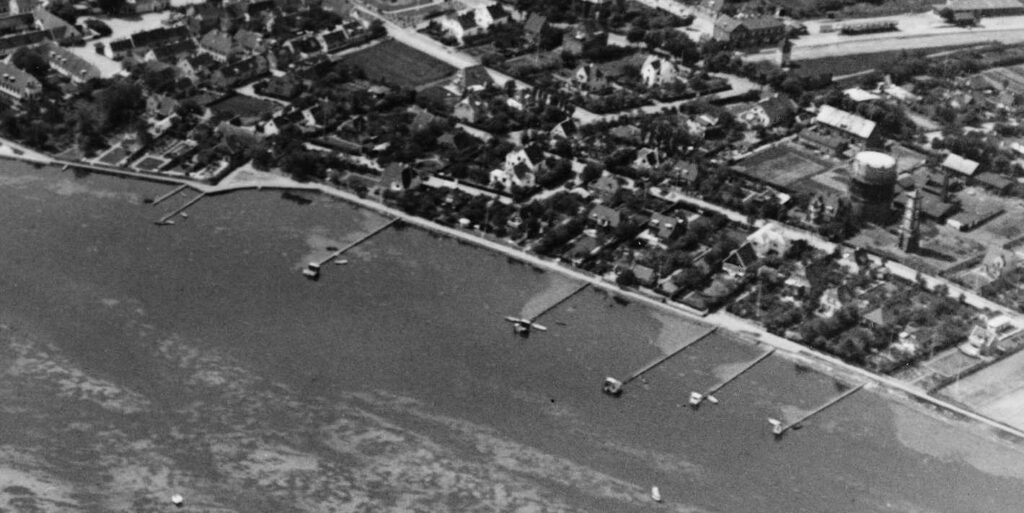 Ca. 1935. Enhver grundejer på Strandstien, med respekt for sig selv, havde sin egen badebro. Der kunne opstå problemer, når grundene blev delt. Hvem skulle have ret til at have en badebro? Længere mod nord kom det til direke slagsmål og hærværk på badebroer, når naboer ikke kunne enes. Foto: Det Kgl. Bibliotek.