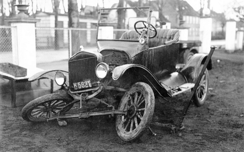 1930. Automobilister kender Mekaniker Andersen, der nu er ansat i Autoparken. Bag vognen, som mekaniker Andersen skal i gang med, ses den gamle transformatorstation på Dragør Kirkegård. Privatfoto.