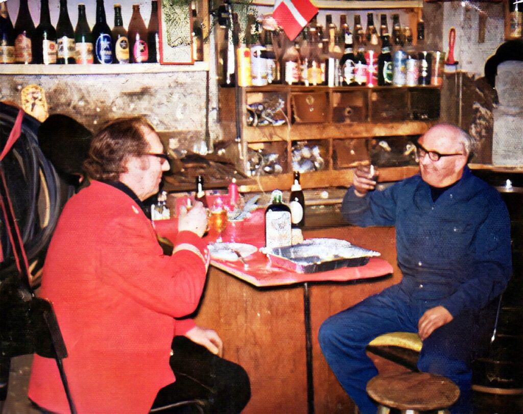 1974-1975. Postbud Helge Strøbech holdt pause hos cykelhandleren. Når det var jul sørgede datteren Vicki for, at der var pyntet op med hvid dug, julelys m.v. ”Husk nu også skylleskåle”, sagde hendes far ofte. Forretningen var lukket. Mange kiggede forbi og vinkede ind. Foto: DB-arkiv..