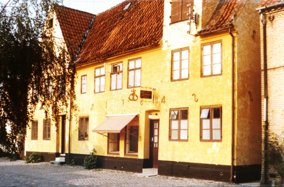 Ca. 1974. Ejendommen Strandstræde 8 er opført i 1784, som man ser på facaden. Samme dag som Jens Peter Andersen lukkede sin cykelforretning i 1976, lukkede Knud Jørgensen sin bagerforretning. Da ejendommen blev ombygget til ejerlejligheder, blev den sydlige indgang flyttede til den oprindelige placering. Foto: DB-arkiv.