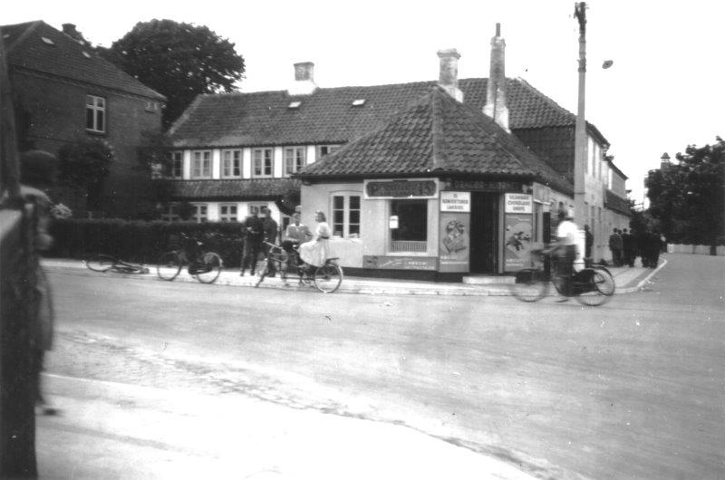 Ca. 1940. "Kokkens hjørne". Ud for forretningen skimtes to tyske soldater. Foto taget af deres kammerat fra konditor Volmer Louws forretning Kirkevej 5 (nu Kirkevej 174). DB-Arkiv.