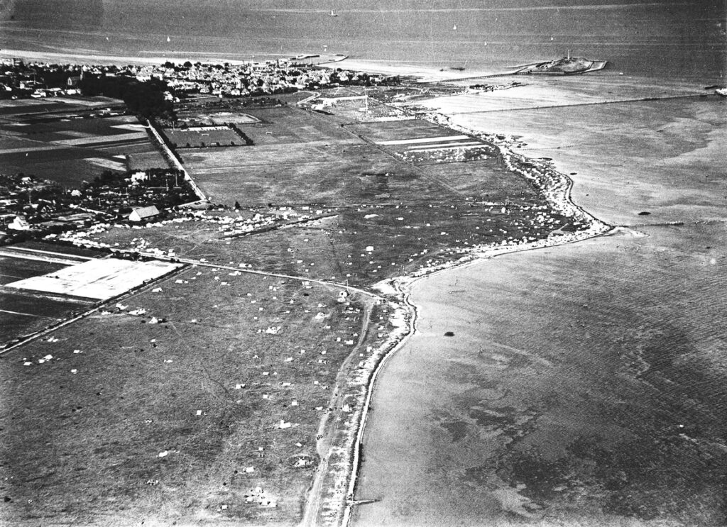 Sommeren 1933. Dragør Sydstrand set mod Dragør gl. by, havn og fort. Foto: Kgl. Bibliotek.