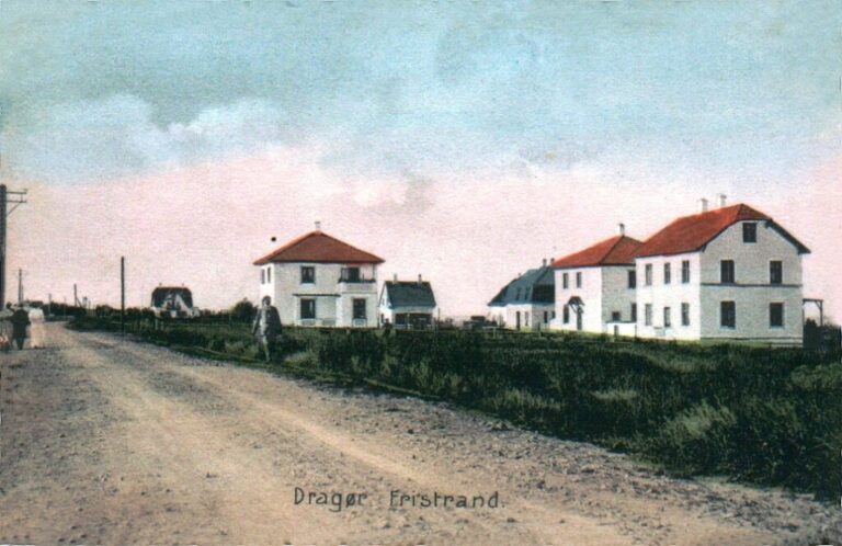 Ca. 1918. Stationsvej set mod nord. De tre store hvide villaer er nr. 33, 35 og 37. Mellem villaerne ses Fristrands Allé 6, 8 og 3. I baggrunden på Nordstranden ses “Villa Fyrbakken”, som Charles Hansen byggede. Måske har udgiveren af postkortet været i gang med datidens “Photoshop”. Villaen i nr. 31 mangler, men den ville have domineret for meget og dækket de øvrige. Manden, der er på vej til stationen, er sikkert indtegnet? (Håndkoloreret postkort udlånt af Jørgen Aamand).